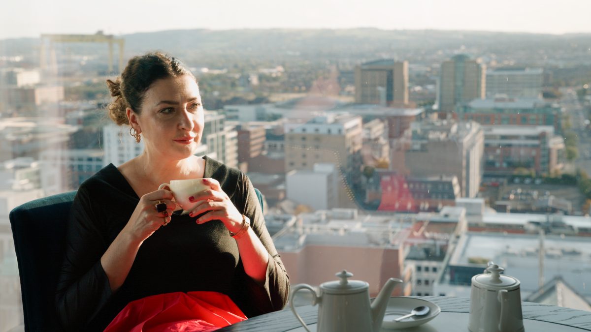 lady sitting in front of a window look over belfast 